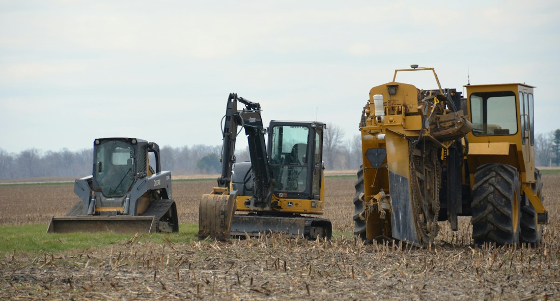 Heavy construction equipment lined up in a field